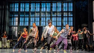 Michael Jackson, played by Miles Frost, performs a dance routine with his backup dancers during a scene in MJ the Musical.
