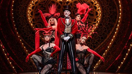 Harold Zidler, the owner of the cabaret Moulin Rouge stands on the stage of the Piccadilly Theatre in London. Image courtesy of Dewynters/ photo credit: Matt Crockett.