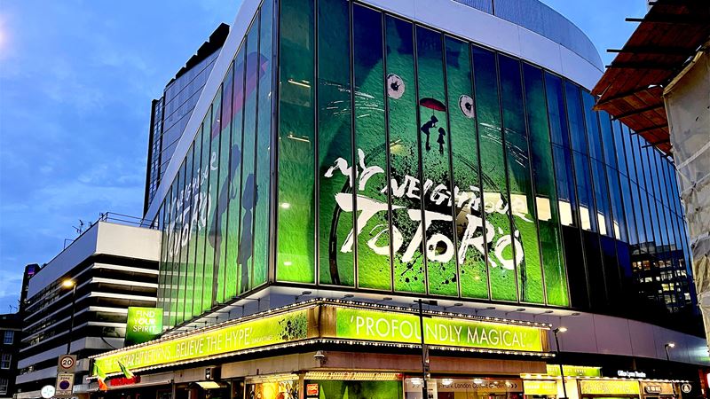 The Gillian Lynne Theatre is proudly lit up in green, with a giant Totoro adorning its façade.