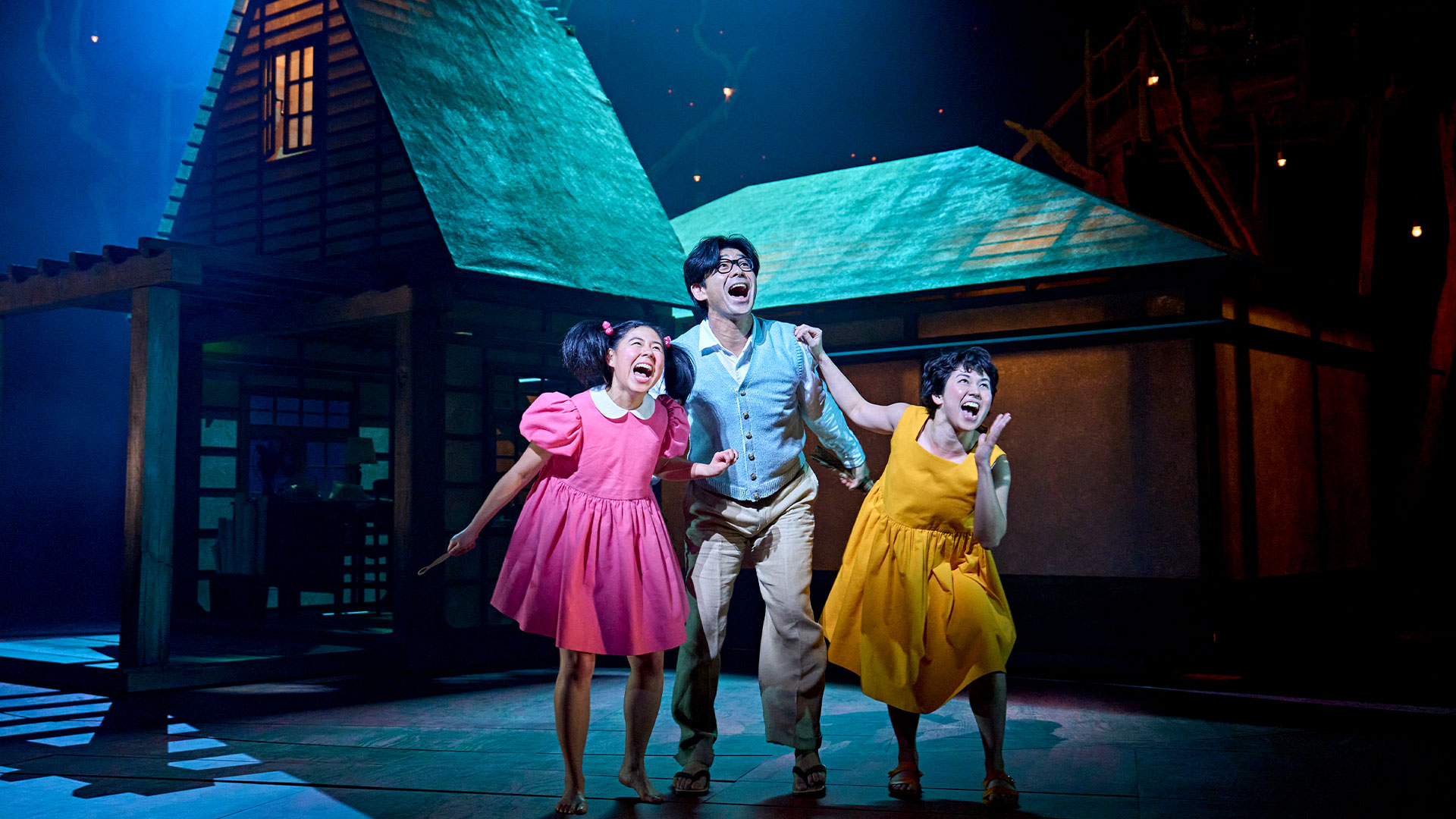 Immerse yourself in wonder as the world of My Neighbour Totoro comes to life in London's West End — a masterpiece not to be missed this season! © Manuel Harlan Mei (Victoria Chen), Tatsuo (Dai Tabuchi) and Satsuki (Ami Okumura Jones) all standing together and laughing during a scene on My Neighbour Totoro stage play.