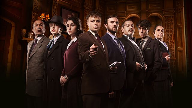 The cast of The Mousetrap, a play by Agatha Christie, look at the camera daringly with Sgt Trotter at the front pointing the finger at the camera.