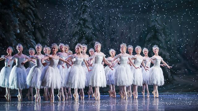 A group of ballerinas dance through falling snow in The Nutcracker.