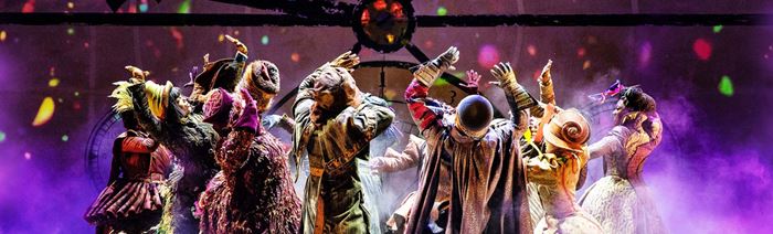 The cast of Wicked the Musical is surrounded by purple fog on the stage of the Apollo Victoria.
