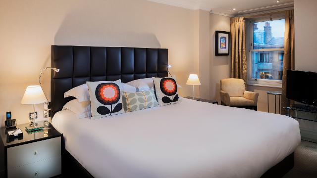 Cheval Phoenix Court, one bedroom. Image courtesy of Four Communications. Double bedroom featuring a double bed with white sheets and colourful cushions.