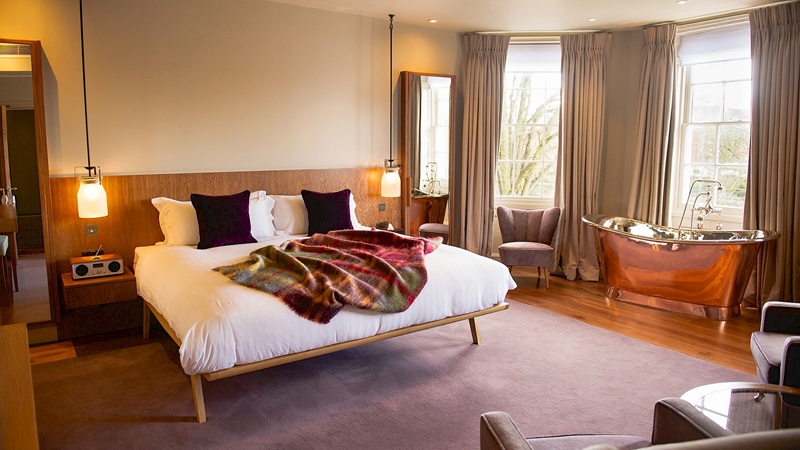 Share a spacious room at the beautiful Bingham Riverhouse. Credit: Bingham Riverhouse. Image courtesy of Bingham Riverhouse. Cosy room at Bingham Riverhouse with a double bed, gold freestanding bath tub and large windows looking out onto the garden
