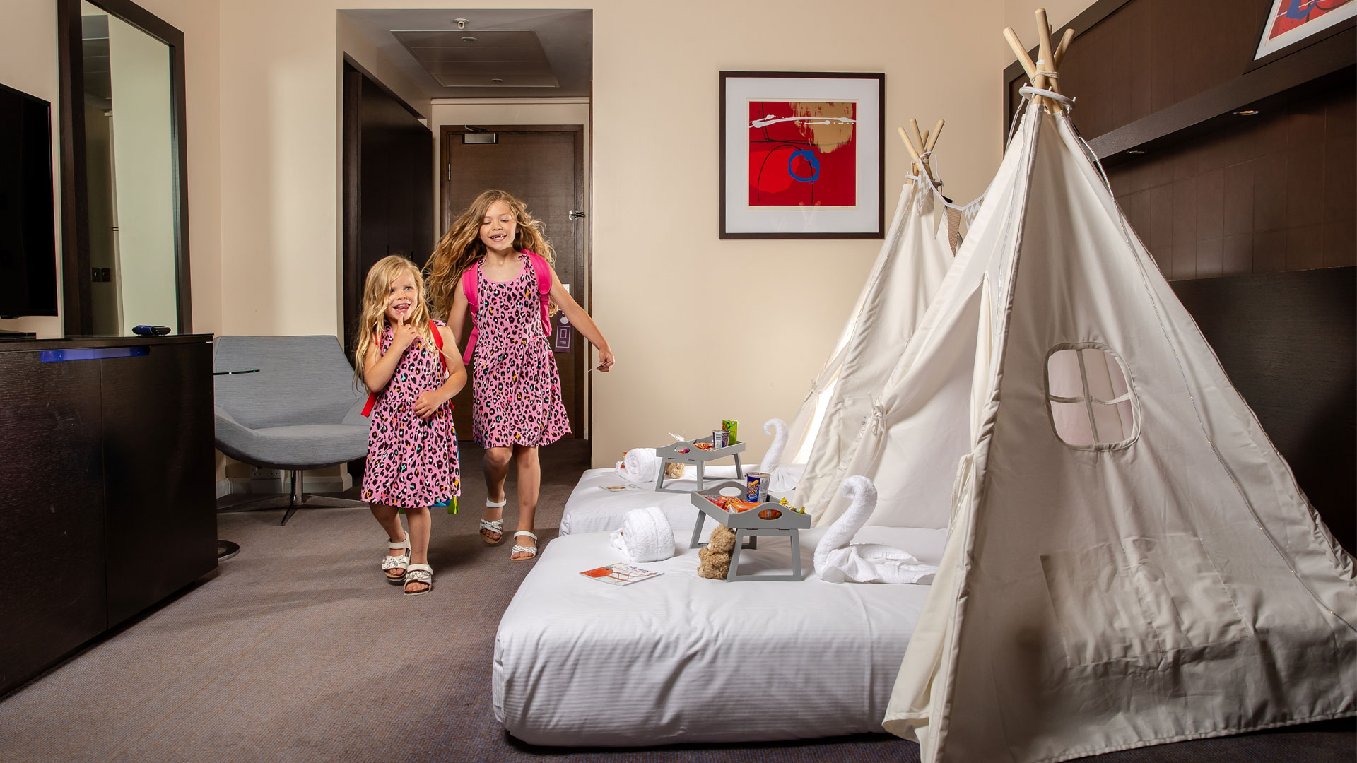 Enjoy a fun family break at Hilton London Canary Wharf. Image courtesy of Hilton. Family room at Hilton London Canary Wharf with tepees and kid's activities on beds.