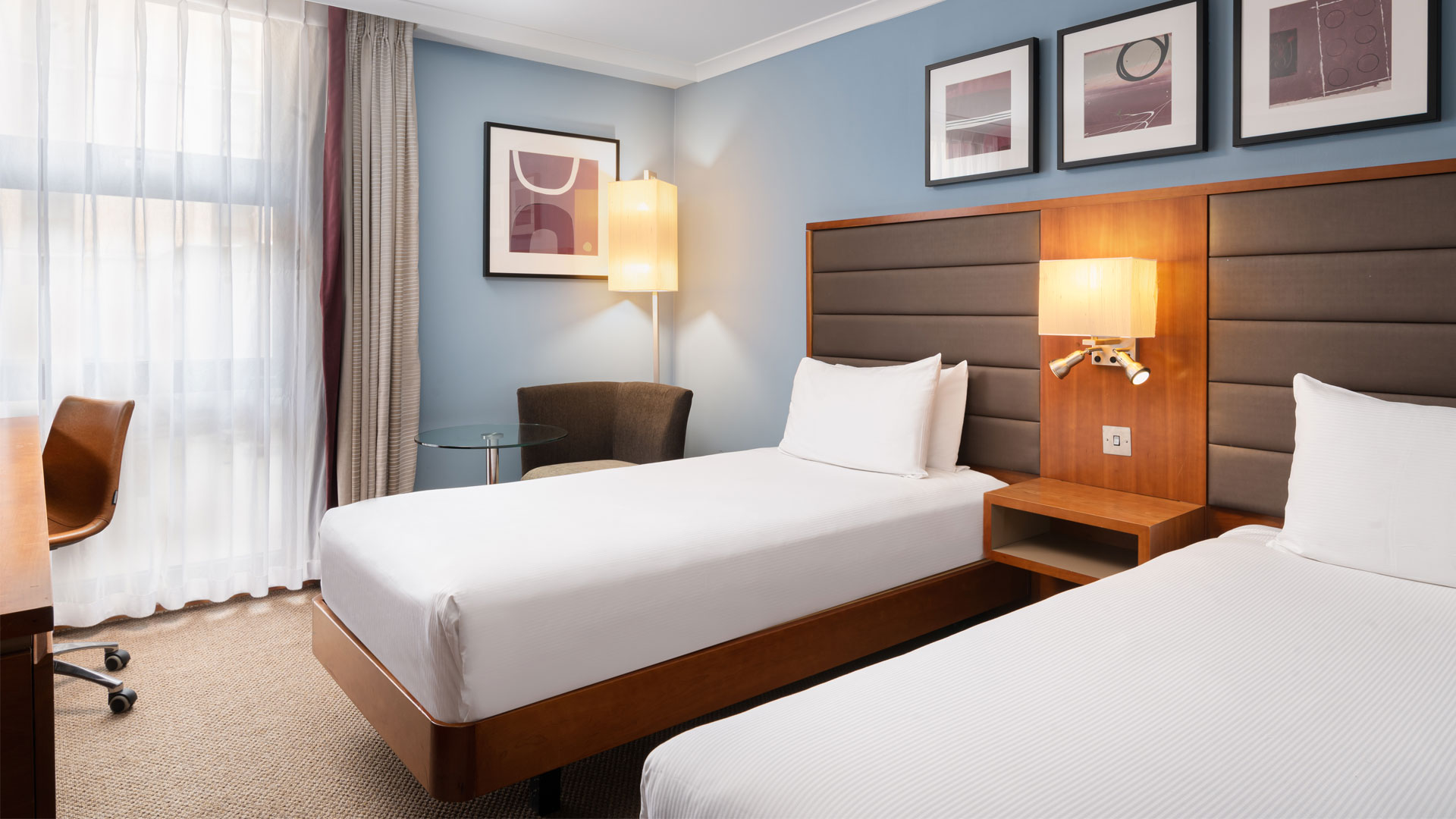 Begin your family city break at Hilton London Kensington. Image courtesy of Hilton. Twin beds in bedroom at Hilton London Kensington.
