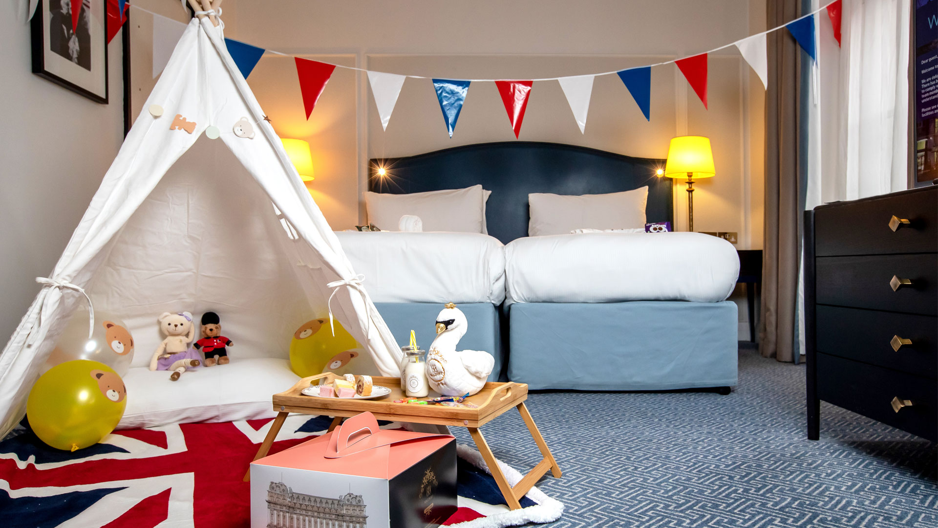 Wake up to London’s top attractions on your doorstep at The Waldorf Hilton London. Image courtesy of Hilton. Twin family room at The Waldorf Hilton London with tepee, bunting and London-themed details.