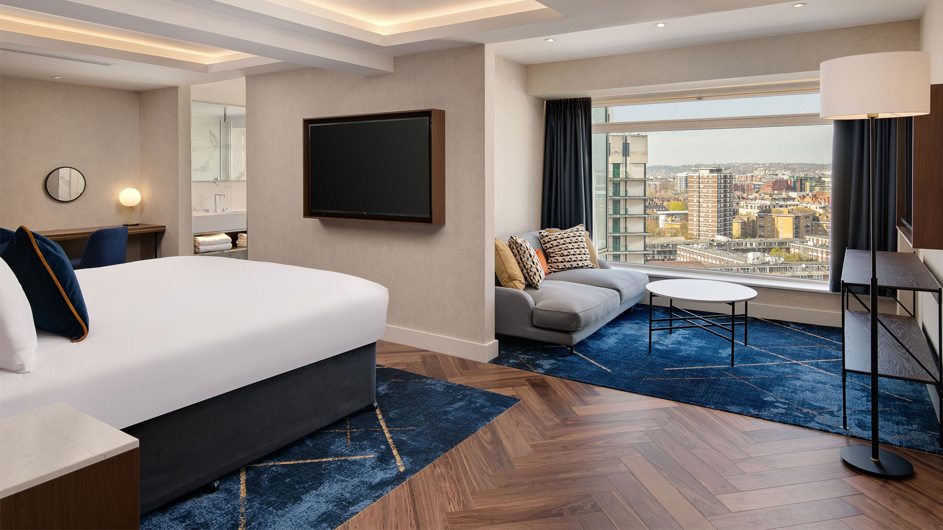 Discover contemporary elegance at Hilton London Metropole. Image courtesy of Hilton. Bedroom and lounge in suite at Hilton London Metropole