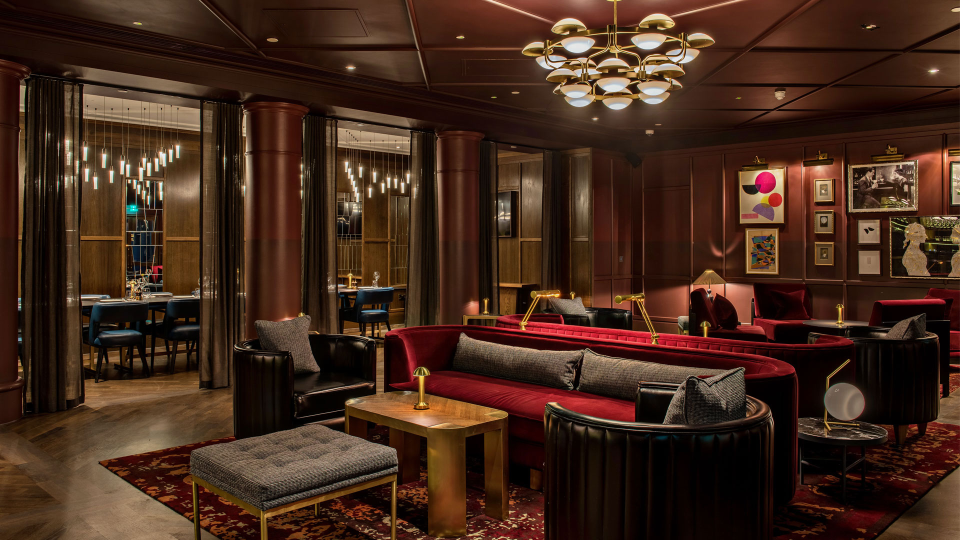 Indulge in chic London living at The Trafalgar St. James, Curio Collection by Hilton. Image courtesy of Hilton. Lounge with dark wood and red seating at The Trafalgar St. James London