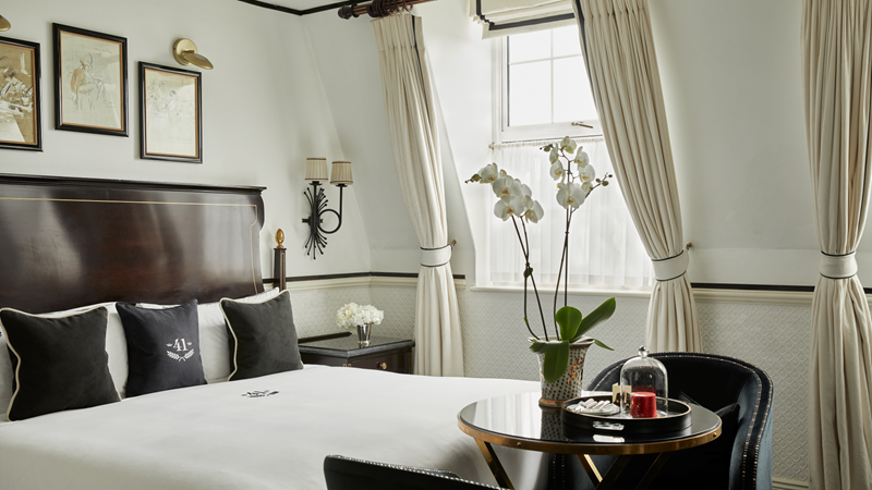 Treat your special someone to a luxurious stay in an Executive King Room at Hotel 41. Credit: Hotel 41. Image courtesy of Hotel 41. Executive king room at Hotel 41 featuring a rich mahogany king-sized bed with a table an two armchairs and framed art filling the walls