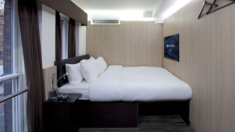 Opt for a low-cost, comfortable stay at Z Soho. Credit: FINN Partners. Image courtesy of FINN Partners. A basic room with a double bed, bedside table, wall-mounted TV and windows
